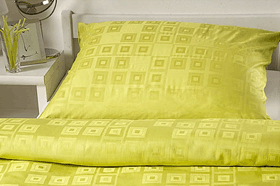 Žlutý polštář a žlutá peřina - povlečení v posteli